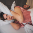 Stop Snoring, Frustrated woman covering her ears with a pillow while her partner snores loudly in bed next to her